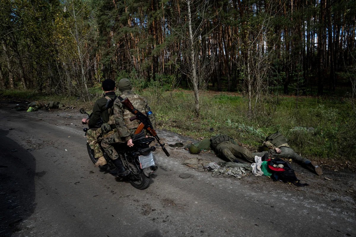 Ukrainian servicemen driving past the bodies of Russian soldiers, Lyman, Ukraine, 3 October 2022. Photo: Yevgeny Maloletka / AP Photo / Scanpix / LETA