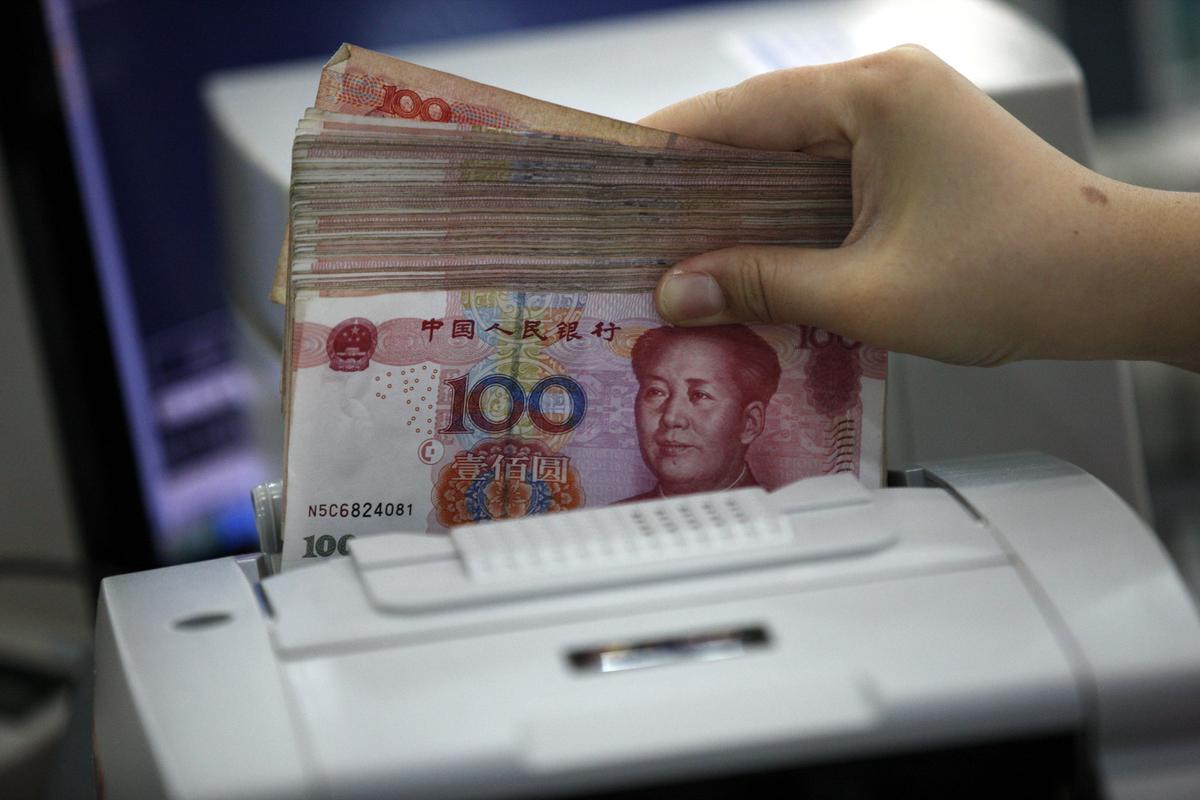 A bank clerk counts Chinese yuan notes. Photo: EPA / WOO HE