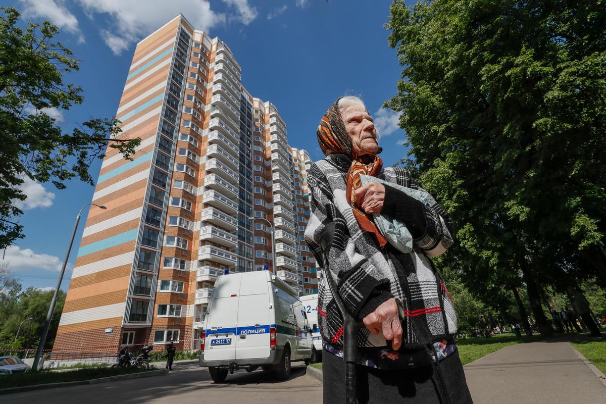 Пожилая женщина стоит перед поврежденным жилым домом после сообщения об атаке беспилотника в Москве, Россия, 30 мая 2023 г. Фото: EPA-EFE/YURI KOCHETKOV