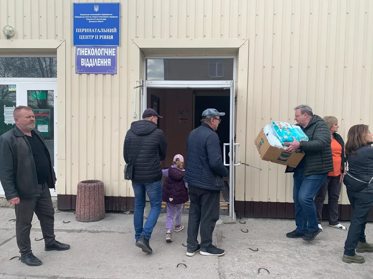 Volunteers from Kyiv unload humanitarian supplies at the Perinatal Centre in Pokrovsk (Yuri Borodin, the centre’s director general, is carrying a box with nappies). Photo: Olga Musafirova