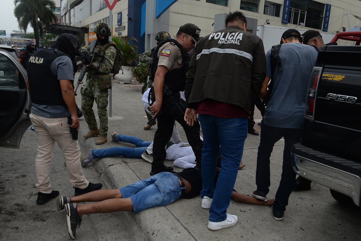 Эквадорская полиция арестовывает нескольких вооруженных людей, ворвавшихся на съемочную площадку общественного телеканала, 09 января 2024 года. Фото: Jose Orlando Sanchez Lindao / Anadolu / Getty Images