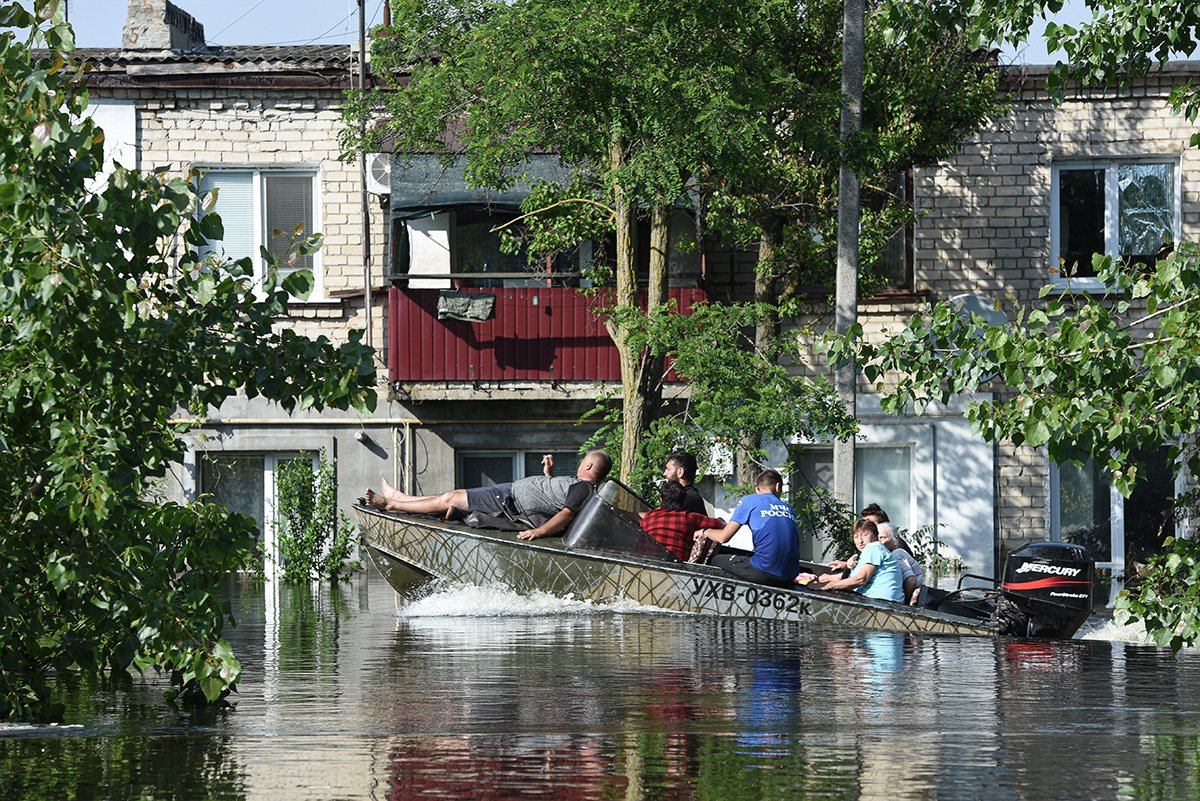 Сотрудники МЧС эвакуируют людей из затопленных жилых районов после разрушения плотины Каховской ГЭС, 8 июня 2023 года. Фото: Stringer / Anadolu Agency / Getty Images