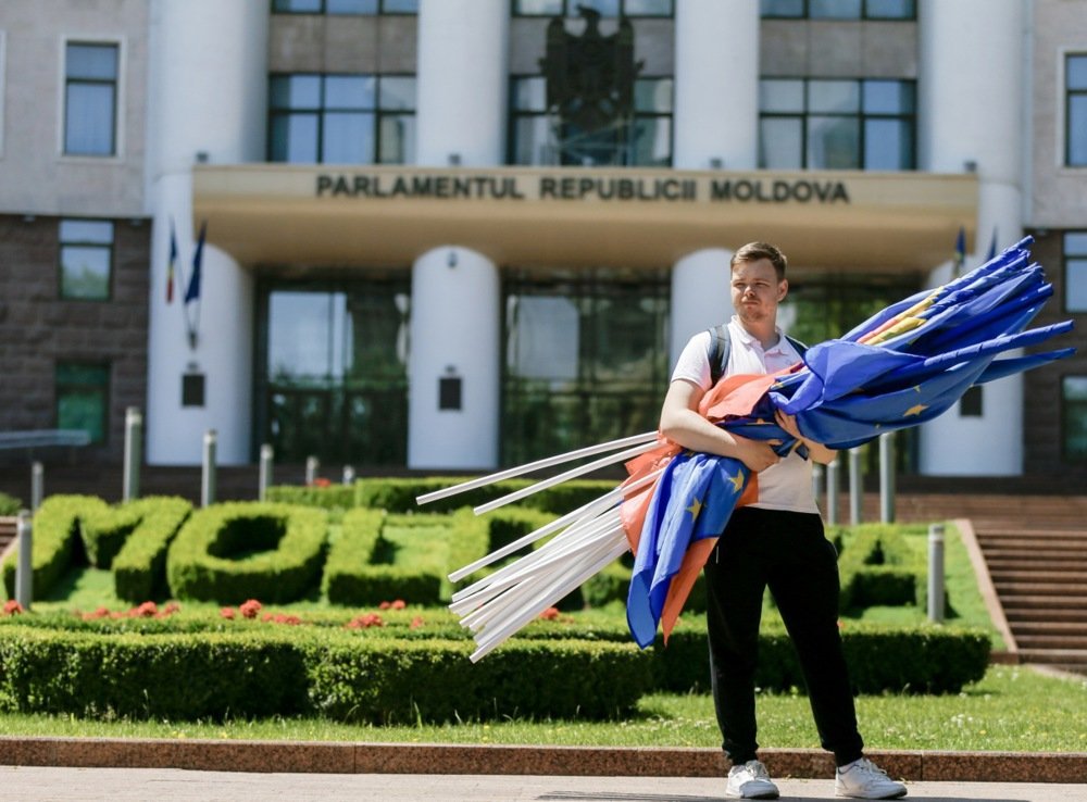 A young man holds flags after a march of PAS Youth, in front of Moldova’s Parliament in Chisinau, Moldova, 01 June 2024. Photo: EPA-EFE/DUMITRU DORU