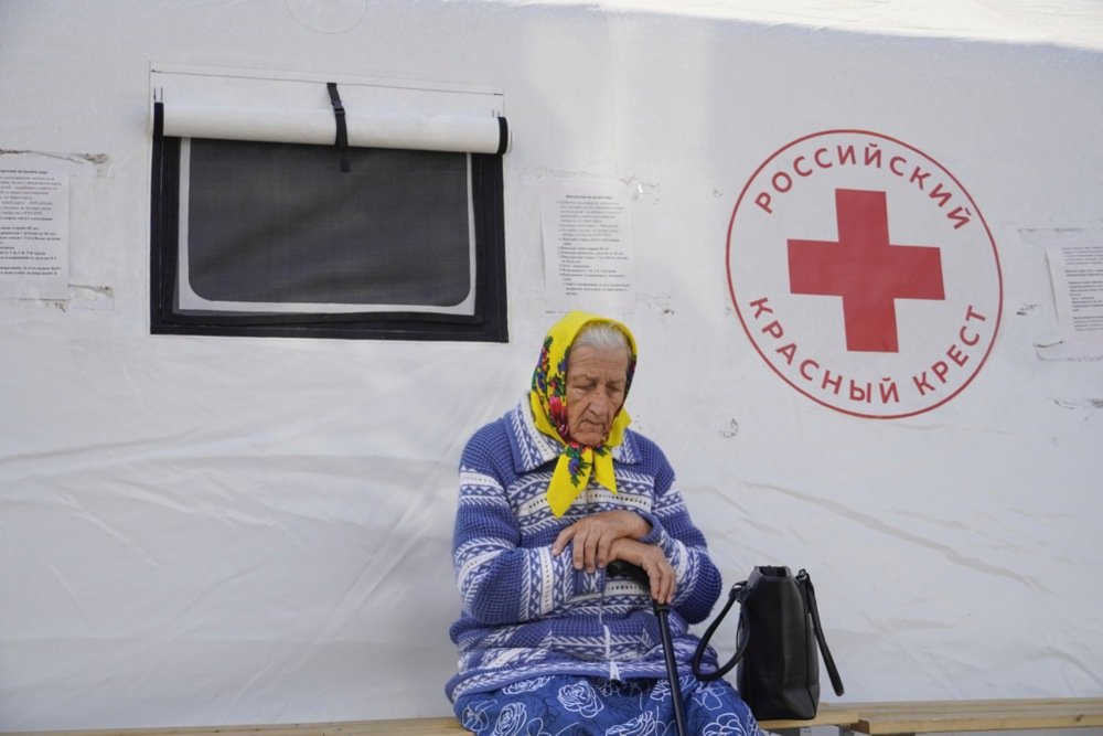 An elderly woman evacuated from the border area of the Kursk region waits to receive humanitarian aid at a Russian Red Cross station in Kursk, 10 September. Photo: EPA-EFE/STRINGER