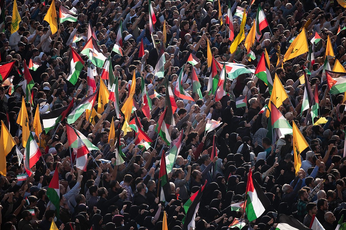 Толпа людей с палестинскими флагами, флагами Ирана и ливанской группировки «Хезболла» на площади Энгелаб (Революции) во время антиизраильского митинга в Тегеране, Иран, 18 октября 2023 года. Фото: Morteza Nikoubazl / NurPhoto / Getty Images