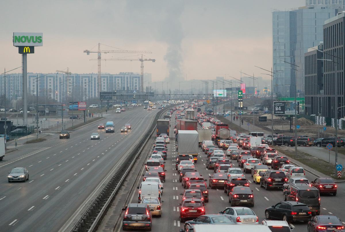 Smoke rises in the distance as Kyiv residents begin fleeing the Ukrainian capital on 24 February 2022. Photo: EPA-EFE/SERGEY DOLZHENKO