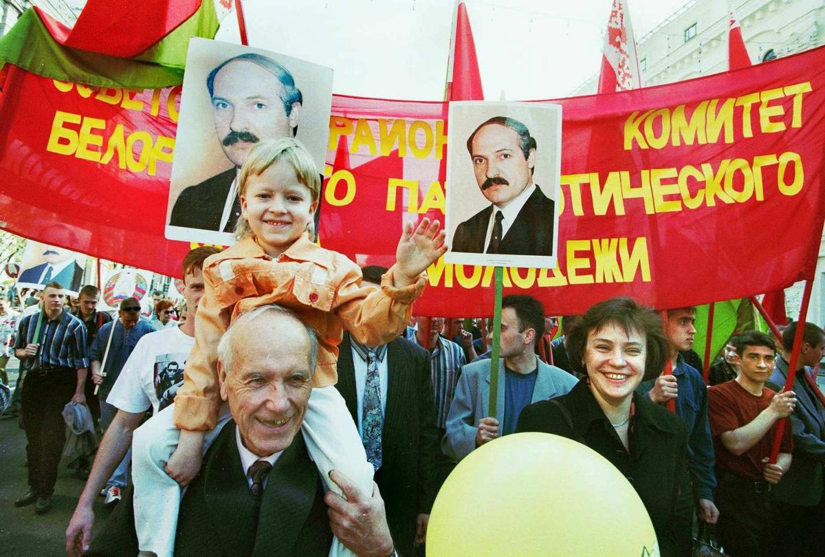 An elderly man carries his granddaughter on his shoulders during May Day celebrations in Minsk, 1 May 1998. Photo: EPA / VICTOR DRACHEV