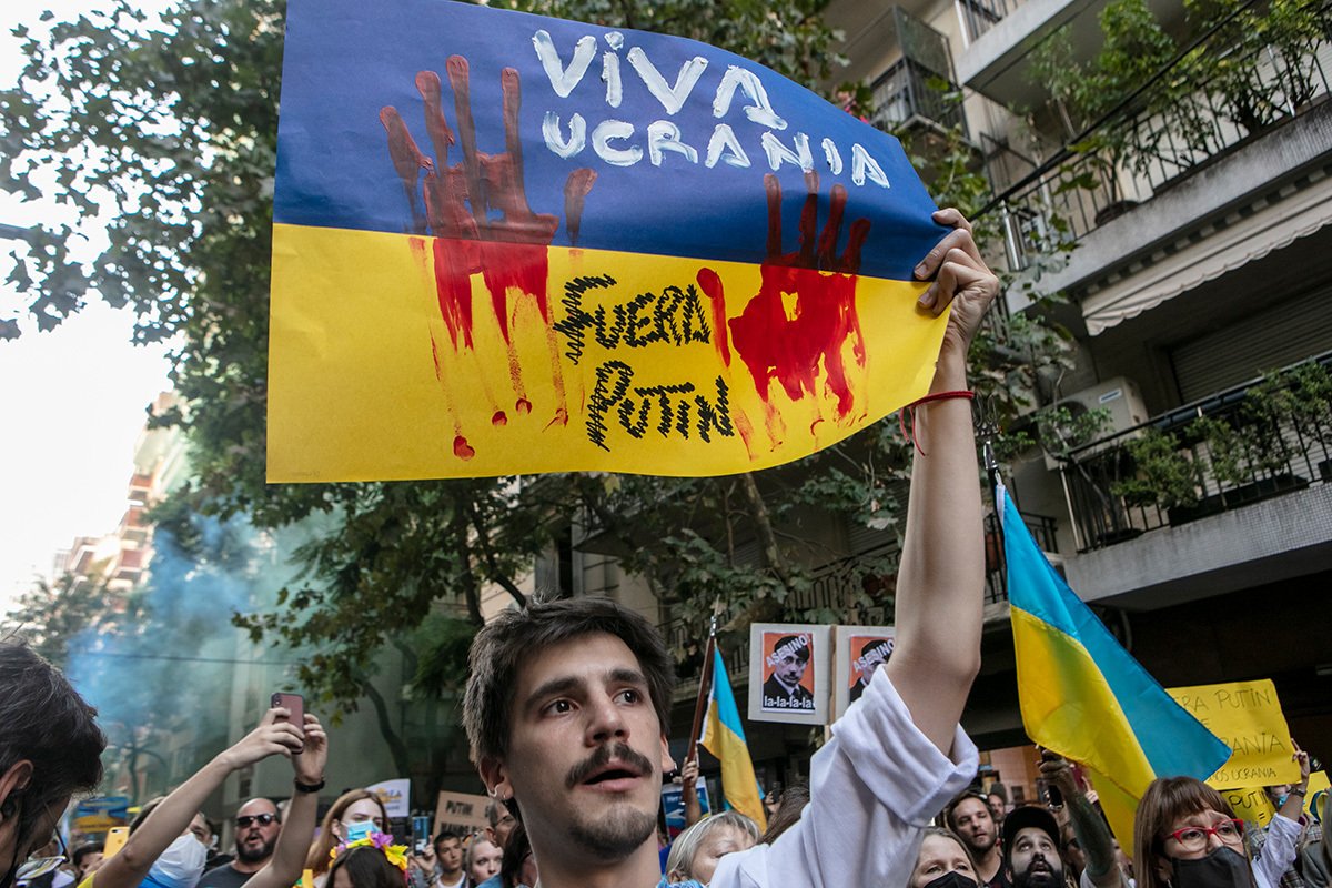 Участники акции держат флаг Украины перед российским посольством в в Буэнос-Айресе в 2022 году. Фото: Juan Ignacio Roncoroni / EPA