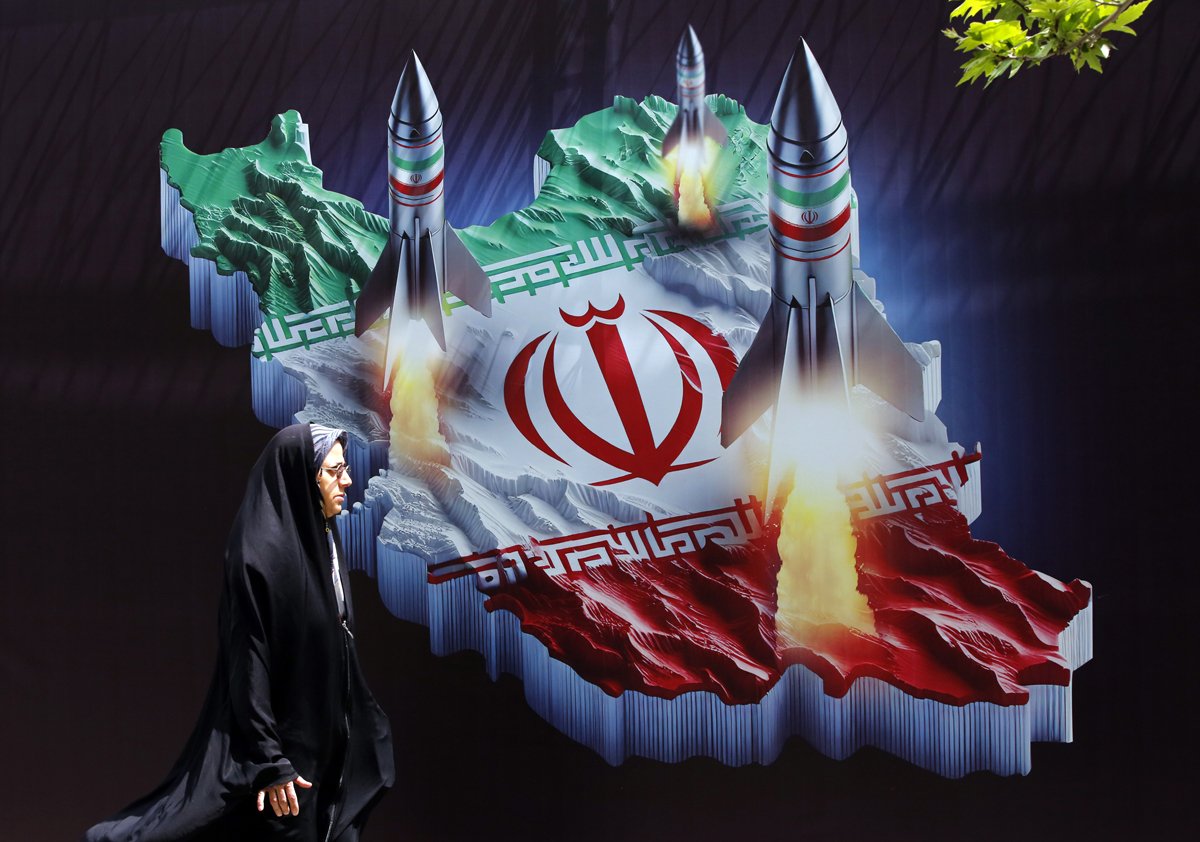 Иранка проходит мимо антиизраильского баннера с изображениями иранских ракет в Тегеране, Иран, 16 апреля 2024 года. Фото: Abedin Taherkenareh / EPA-EFE
