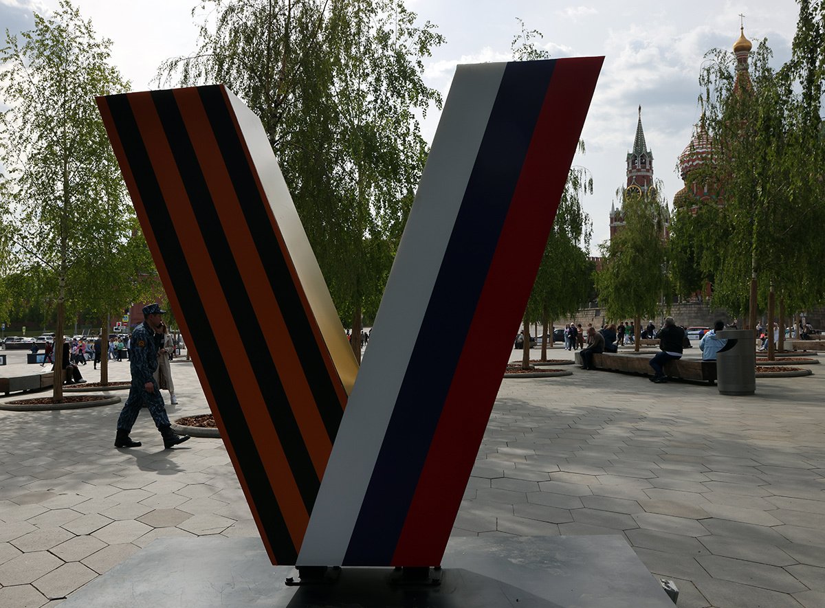 Мужчина проходит мимо гигантской буквы «V», символа военной пропаганды в парке «Зарядье», 12 мая 2023 года в Москве. Фото: Contributor / Getty Images