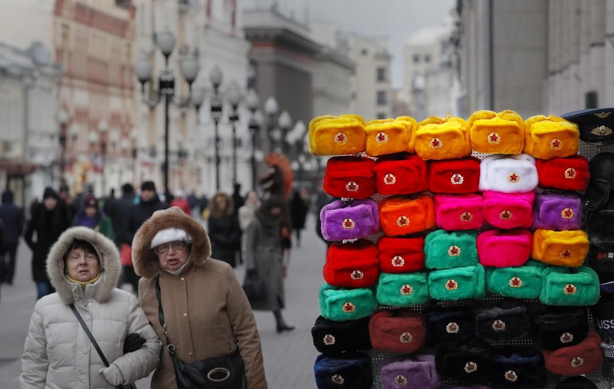 Two women walk past a souvenir stand selling fur hats in Moscow, 14 November 2018. Photo: EPA-EFE / YURI KOCHETKOV