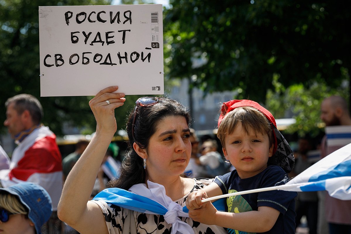 Женщина с ребенком держит плакат «Россия будет свободной» во время демонстрации в Варшаве в День России, 2022 год. Фото: Volha Shukaila / SOPA Images / LightRocket / Getty Images