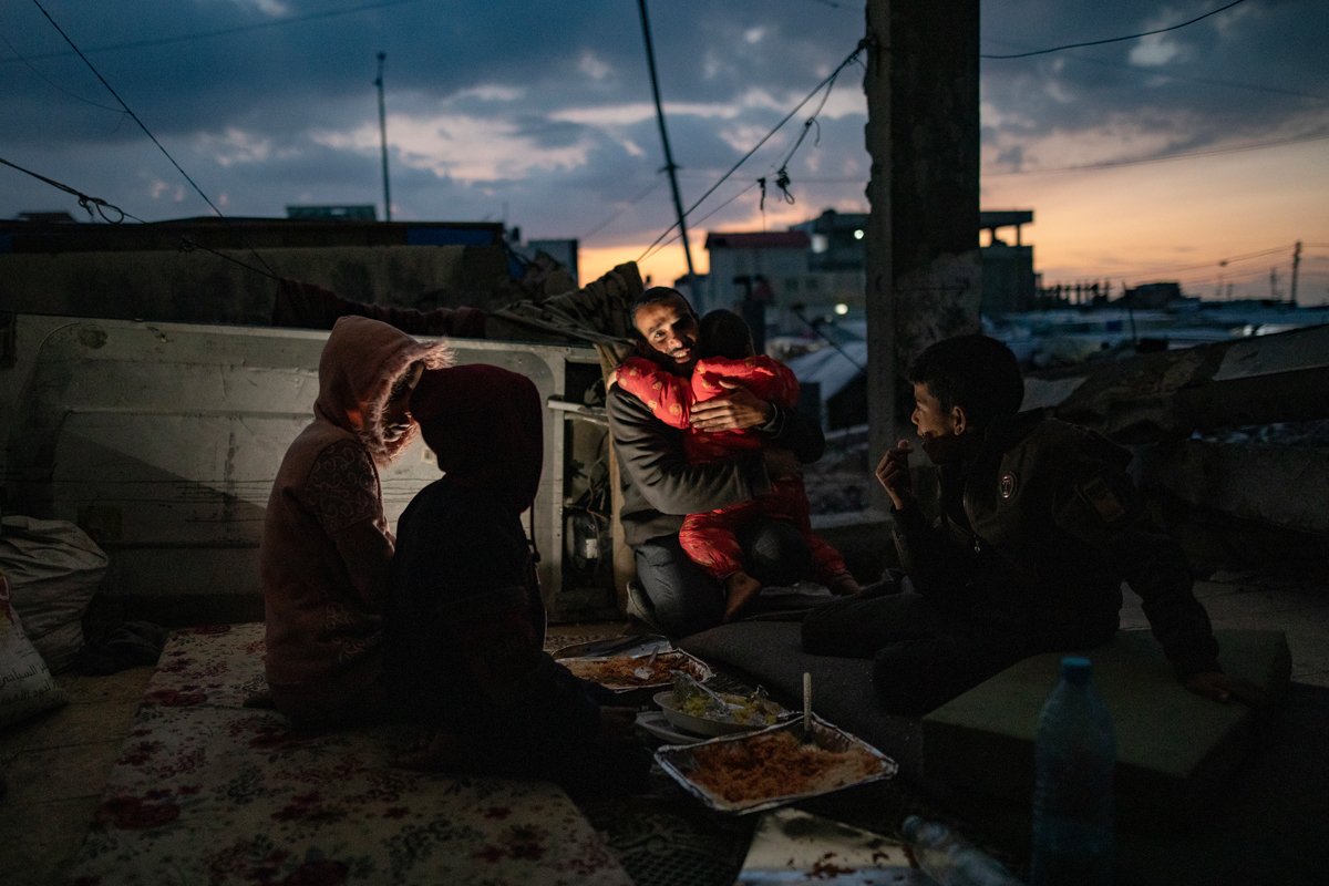 Палестинская семья ужинает в разрушенном доме в Рафахе, 19 марта 2024 года. Фото: Haitham Imad / EPA-EFE