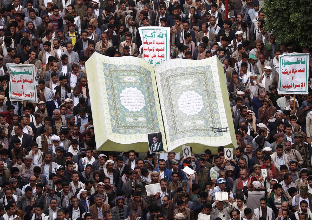 Йеменцы собираются вокруг макета Корана во время акции протеста против осквернения и сожжения Корана в Сане, Йемен, 24 июля 2023 года. Фото: Yahya Arhab / EPA-EFE