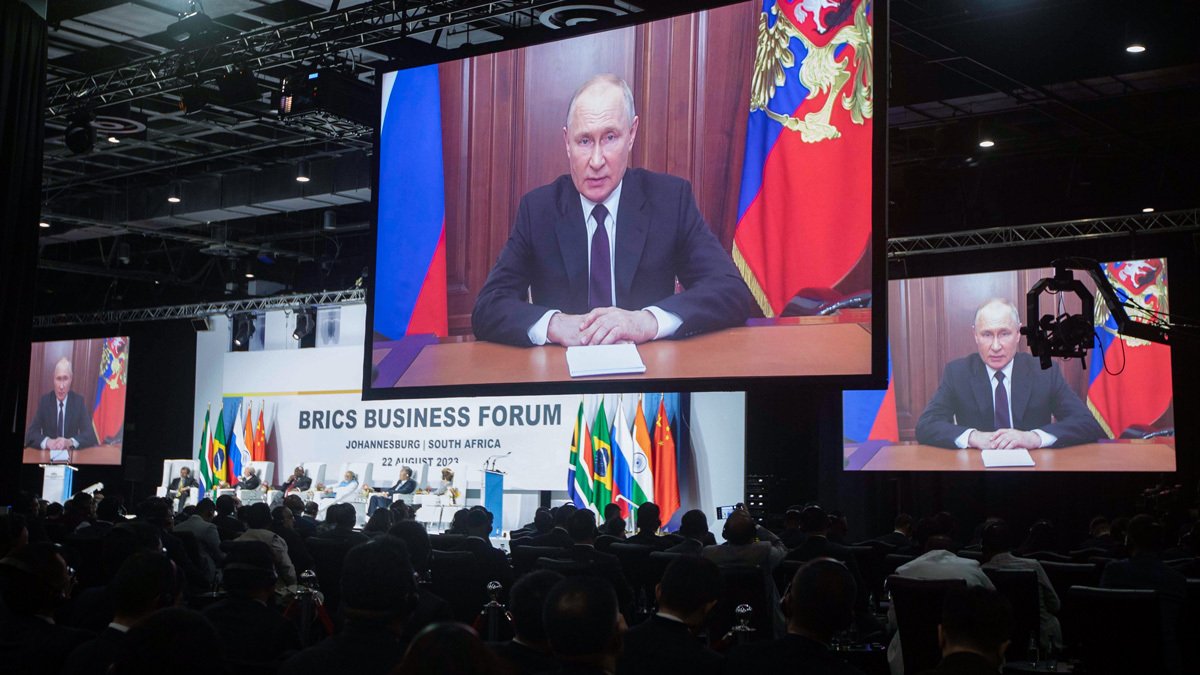 Владимир Путин появляется на экранах во время выступления с записанным выступлением во время 15-го саммита БРИКС в Йоханнесбурге, Южная Африка, 22 августа 2023 года. Фото: Kim Ludbrook / EPA-EFE