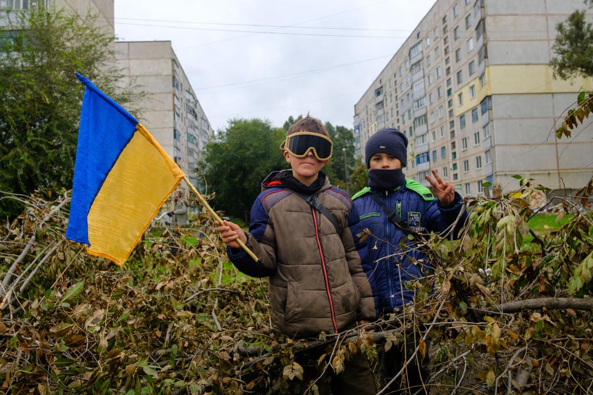 A boy waves a Ukrainian flag in the recently liberated city of Kupiansk in Ukraine’s eastern Kharkiv region, 11 October 2022. Photo: EPA-EFE/George Ivanchenko