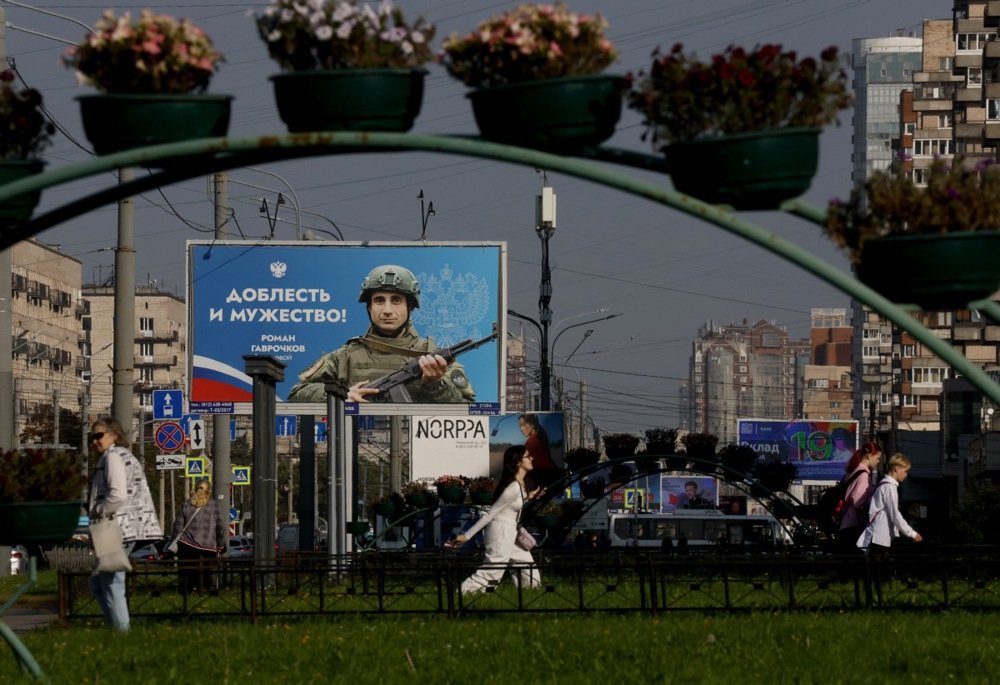 People pass a billboard showing a Russian soldier in St. Petersburg. Photo: EPA-EFE/ANATOLY MALTSEV