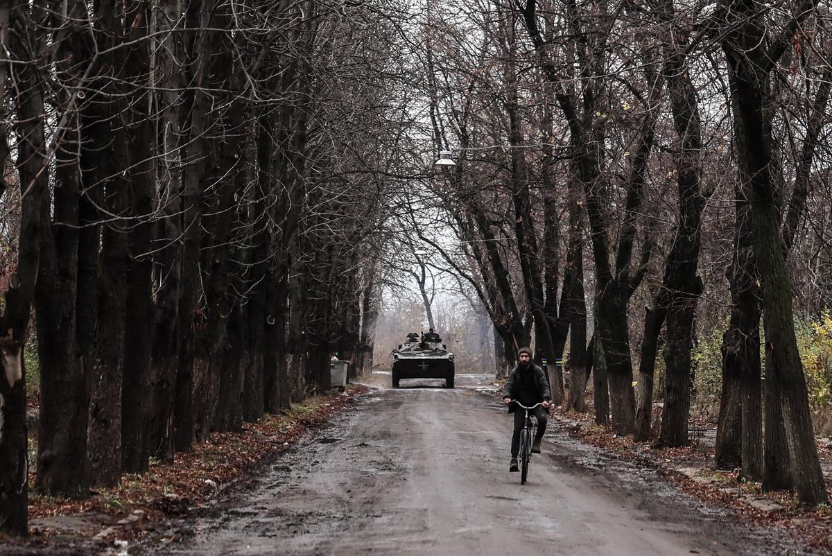 A man cycles ahead of a Ukrainian infantry vehicle in Chasiv Yar. Photo: EPA-EFE/OLEG PETRASYUK