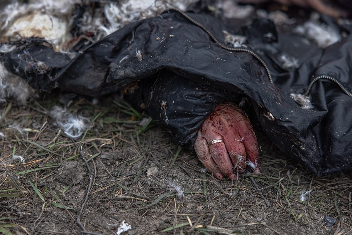 Një grua e vrarë shtrihet në tokë pranë një makine në Bucha, Ukrainë, 6 Prill 2022. Foto: Roman Pilipei / EPA-EFE