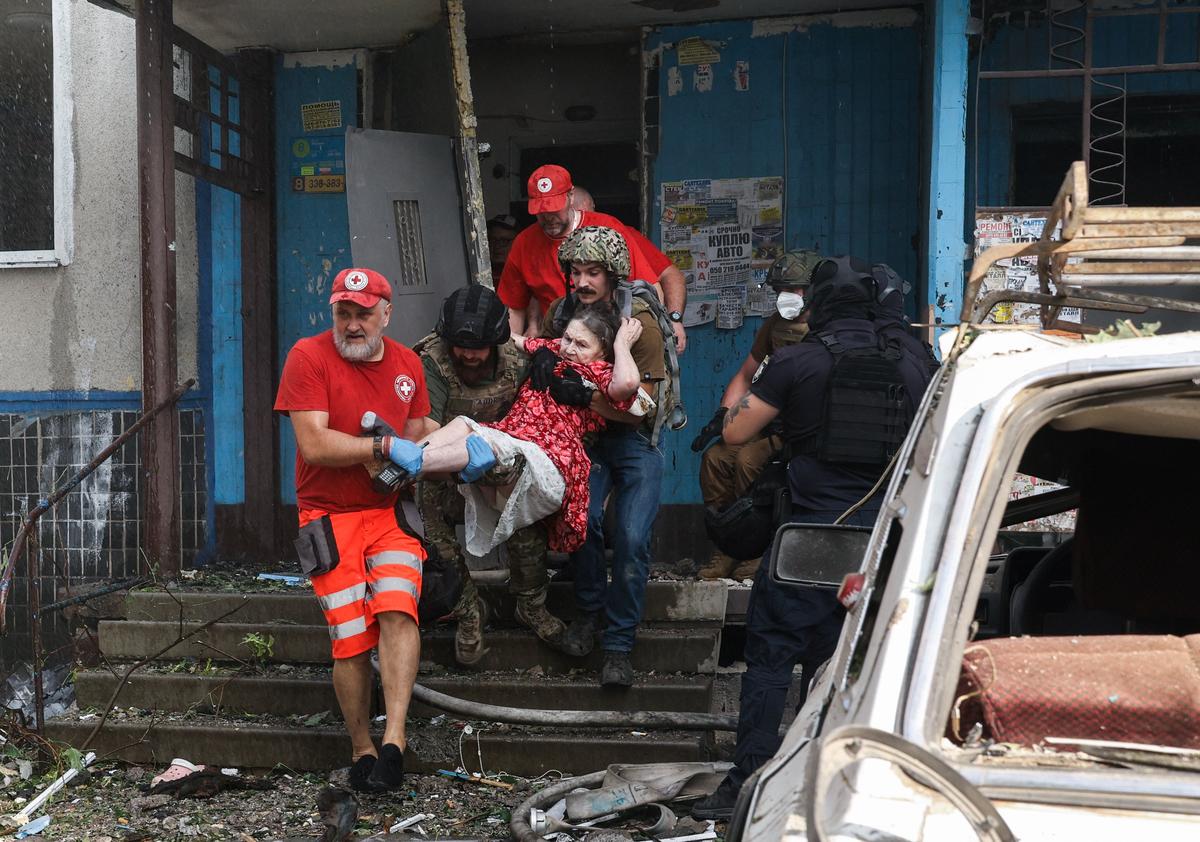 An elderly woman is evacuated from a 12-storey building damaged in a missile strike on Kharkiv, 30 August 2024. Photo: EPA-EFE/SERGEY KOZLOV