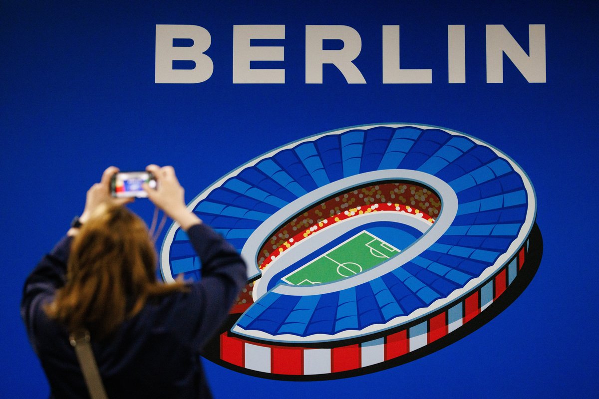 Журналист фотографирует в стилизованное изображение Олимпийского стадиона в Берлине, Германия, 7 июня 2024 года. Фото: Clemens Bilan / EPA-EFE