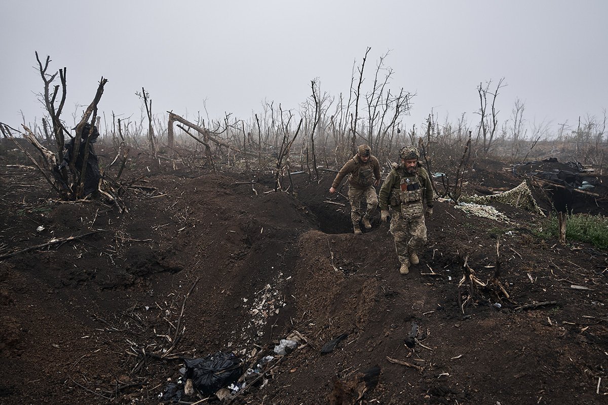 Украинские солдаты идут среди разрушенных деревьев в утреннем тумане в районе Бахмута, 25 октября 2023 г. Фото: Костя Либеров / Libkos / Getty Images
