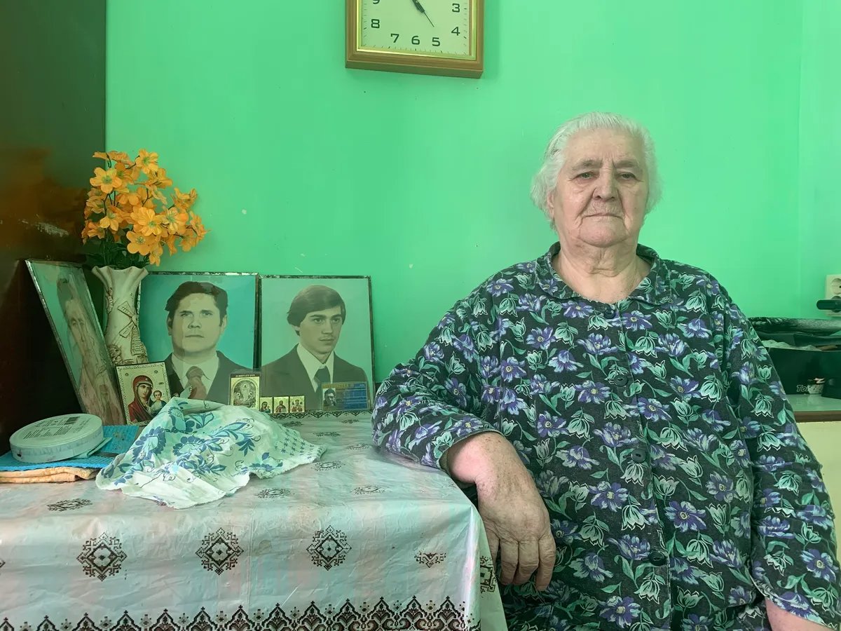 Hanna Hrihoryevna Romaniuk in her house, by the portraits of her late husband and recently killed elder son Mykhailo. Photo: Olga Musafirova, exclusively for Novaya Gazeta Europe