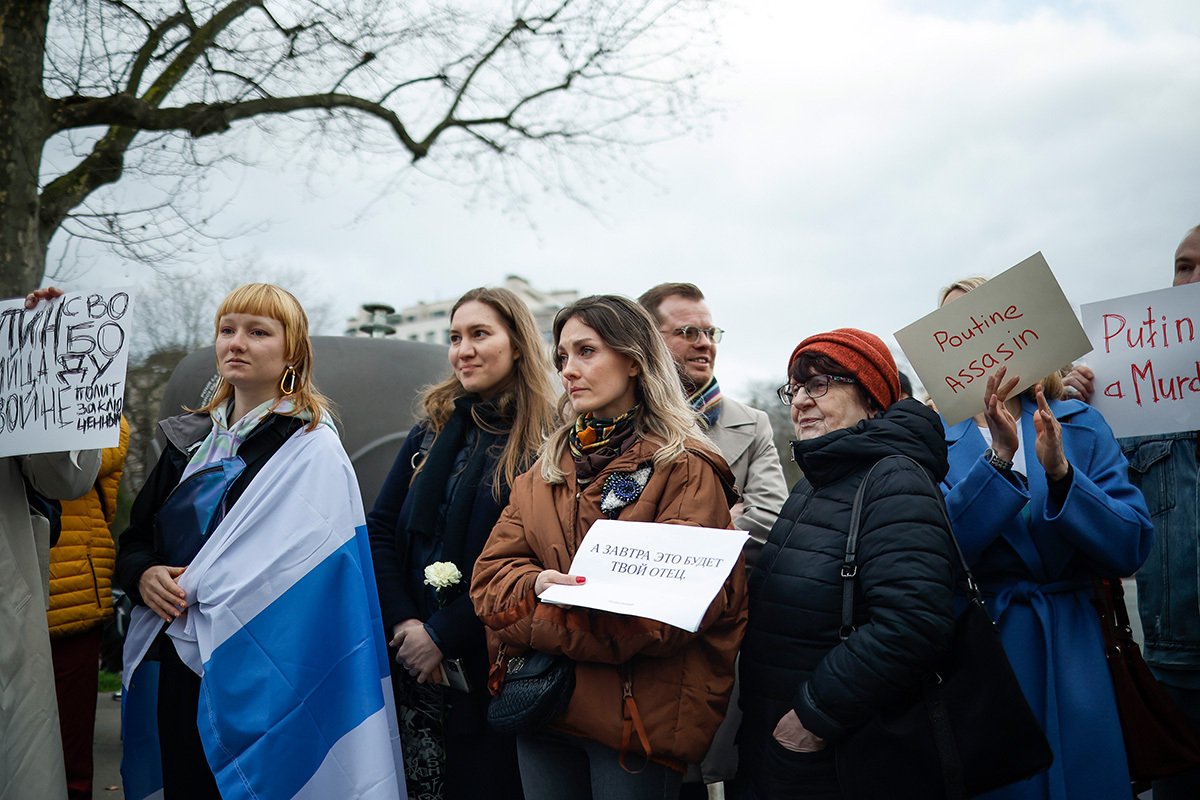 Люди с плакатами «Путин — убийца» собираются на демонстрацию в память об Алексее Навальном возле посольства России в Париже, 16 февраля 2024 года. Фото: Yoan Valat / EPA-EFE