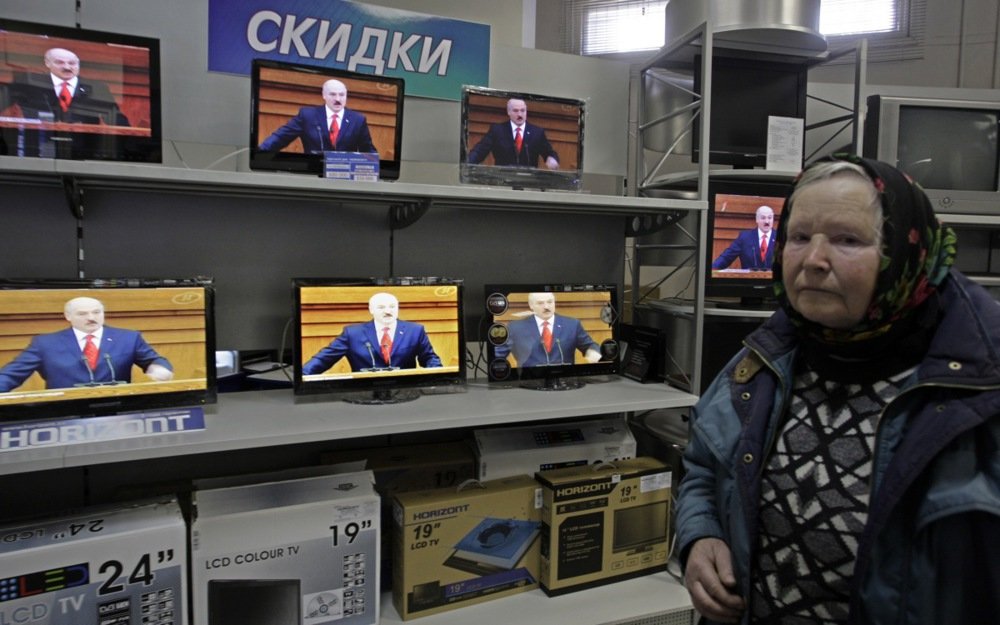 A woman chooses a television set in a shop as Alexander Lukashenko speaks during his annual message to the Belarusian people. Minsk, Belarus, April 2011. EPA/TATYANA ZENKOVICH