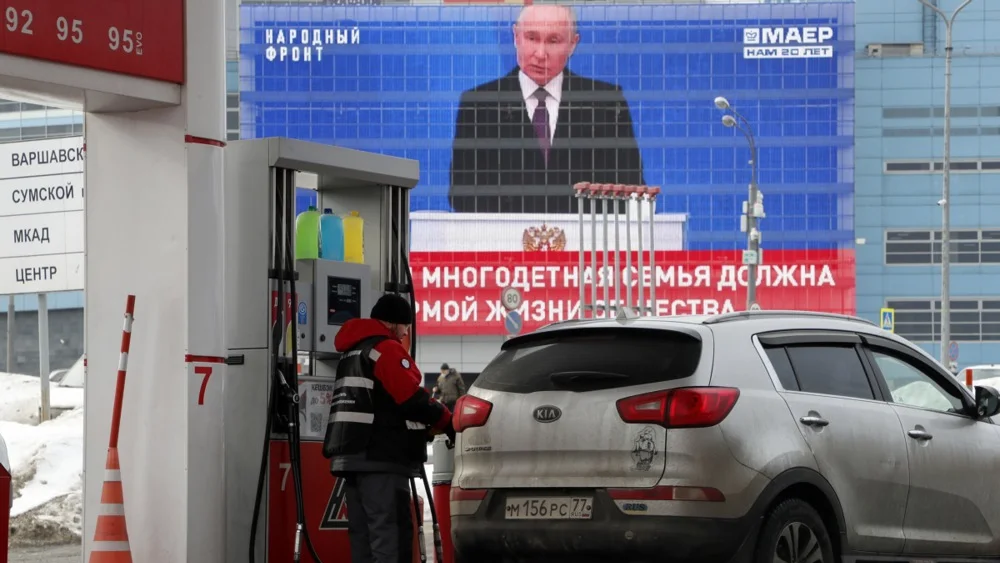Vladimir Putin’s address to parliament broadcast near a petrol station in Moscow on 29 February. Photo: EPA-EFE/MAXIM SHIPENKOV