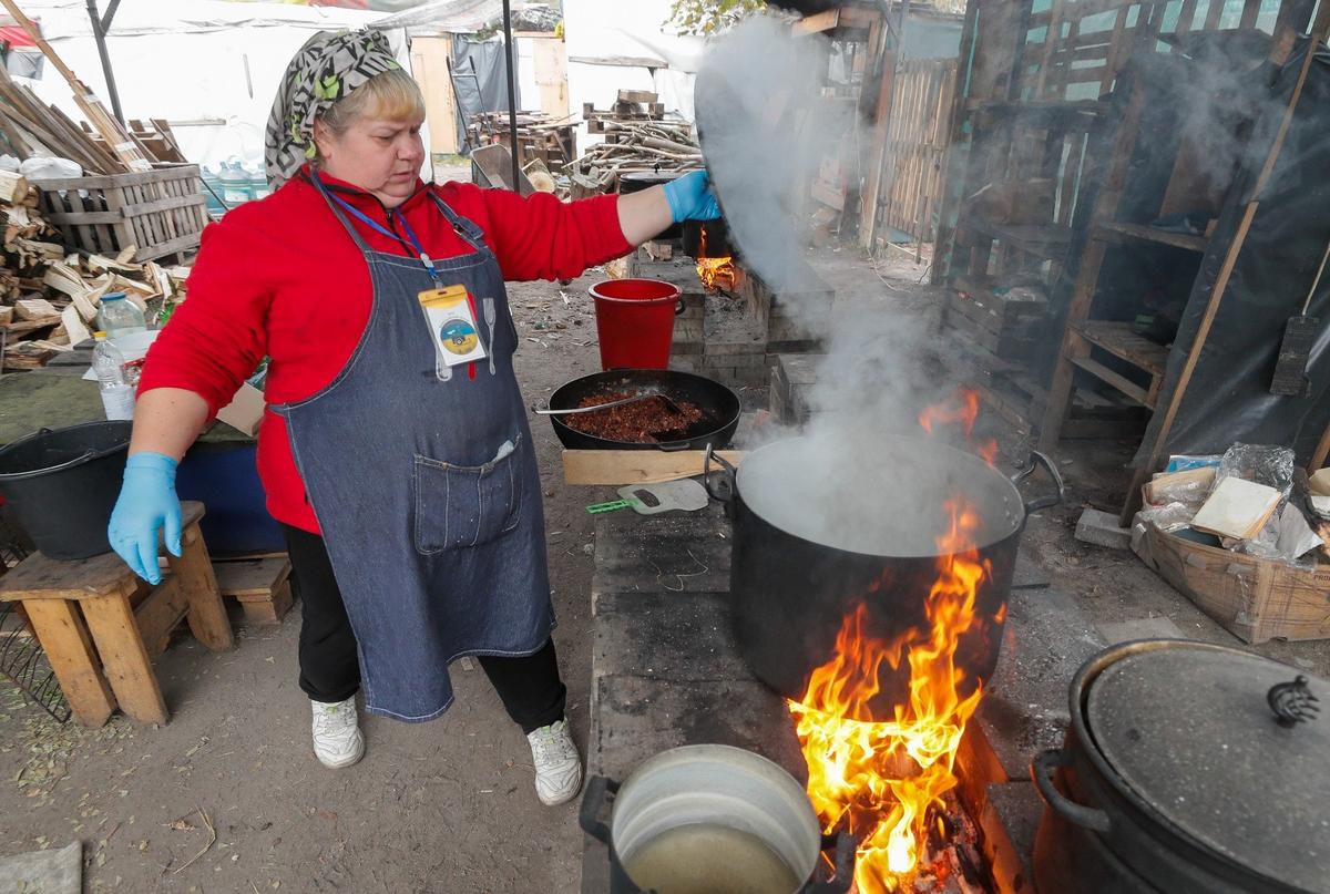 Волонтер готовит горячую еду, которую раздают в Киеве. Фото: EPA-EFE / SERGEY DOLZHENKO