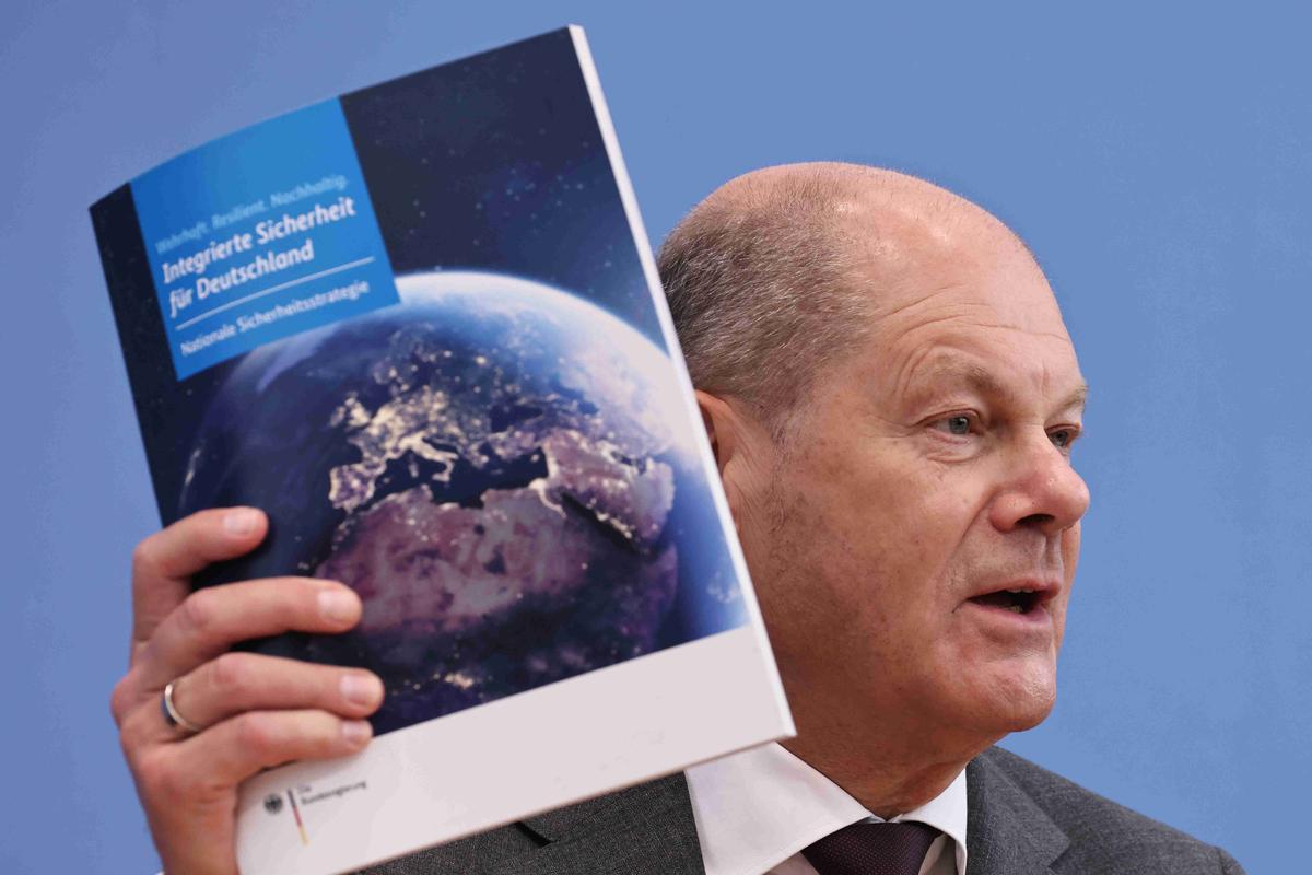 Канцлер Германии Олаф Шольц держит сопроводительный документ Стратегии национальной безопасности, 14 июня 2023 года. Фото: EPA-EFE / CLEMENS BILAN