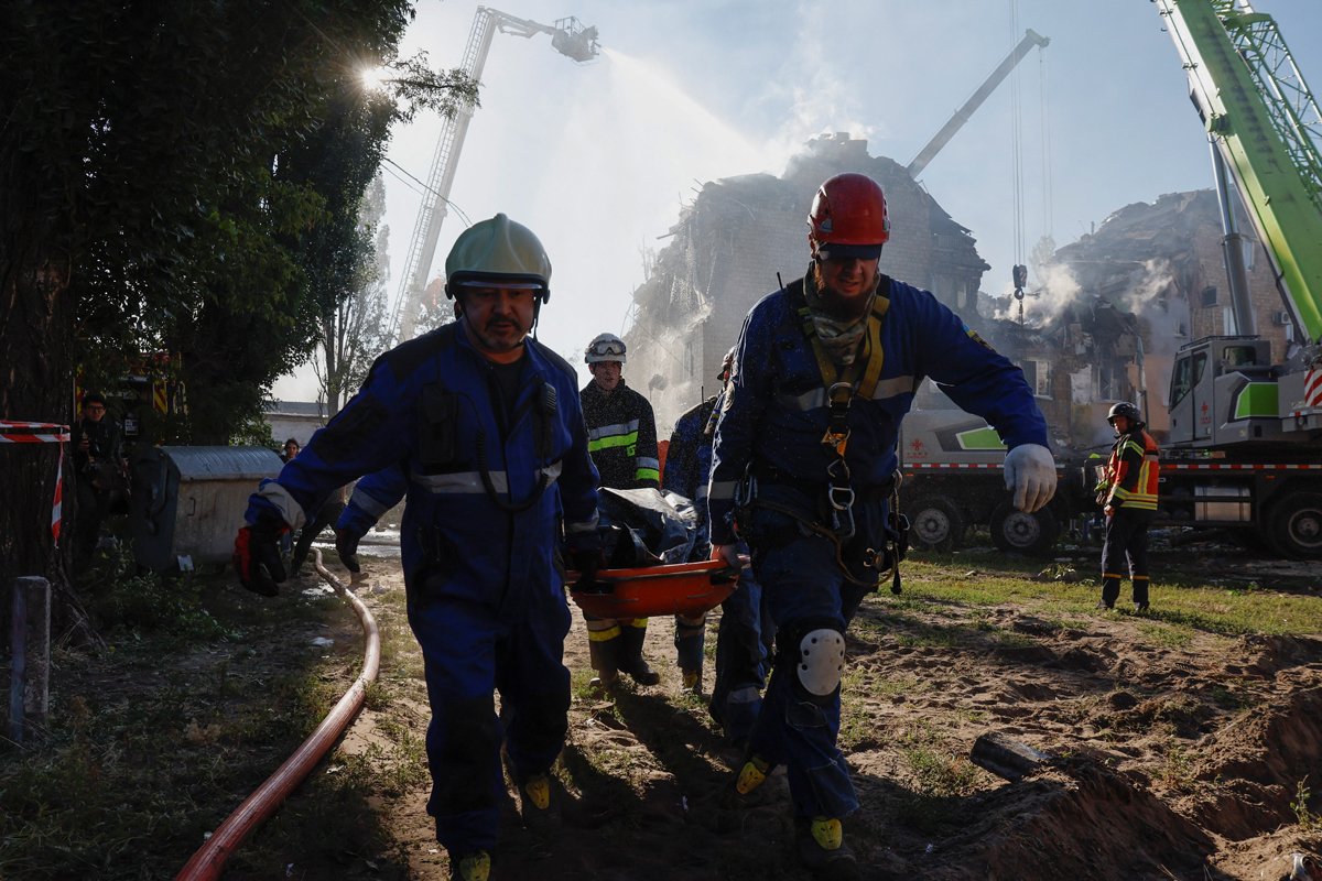 Спасатели несут тело на месте российского удара по Киеву, Украина, 28 августа 2025 года. Фото: Thomas Peter / Reuters / Scanpix / LETA