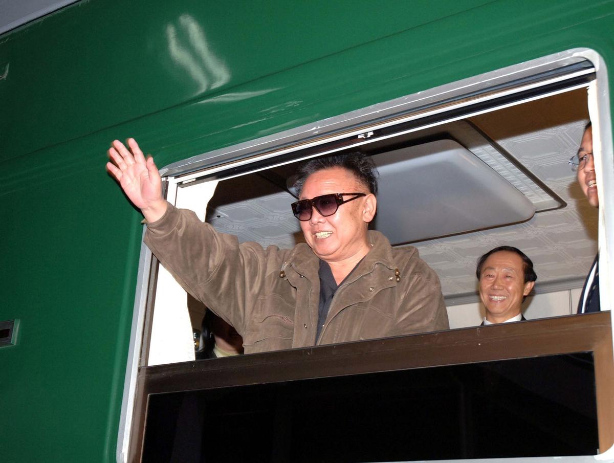 Ким Чен Ир машет рукой из поезда, который вез его с визитом в Китай в январе 2006 г. EPA/YONHAP NEWS AGENCY
