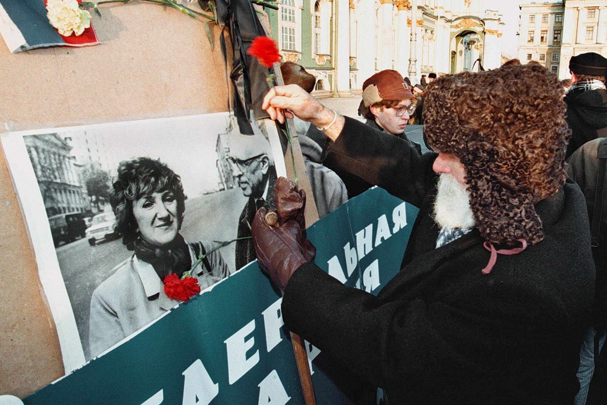 Люли возлагают цветы к портрету убитого депутата Государственной Думы Галины Старовойтовой во время митинга в Санкт-Петербурге, 21 ноября 1998 года. Фото: Анатолий Мальцев / EPA