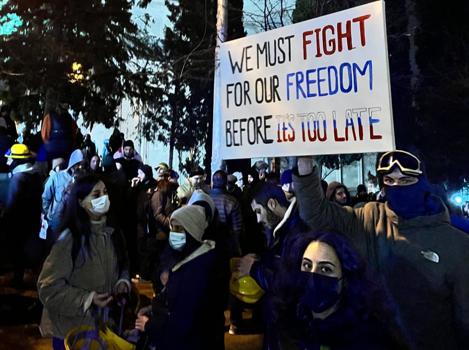 A protester holds up a sign in Tbilisi on 30 November. Photo: Nicholas Pearce for Novaya Gazeta Europe