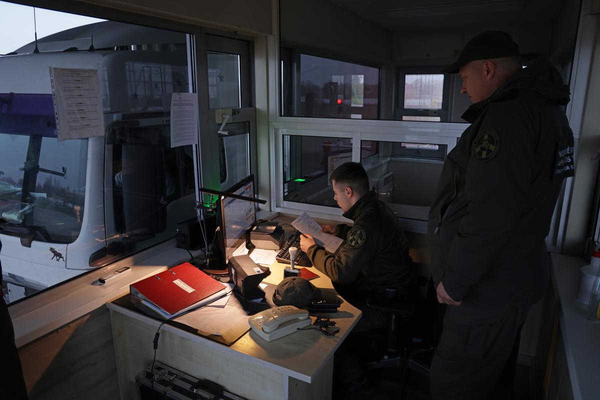 Сотрудники пограничной службы Литвы проверяют документы у водителя на международном пункте пропуска, 28 октября 2022 года. Фото: Sean Gallup / Getty Images
