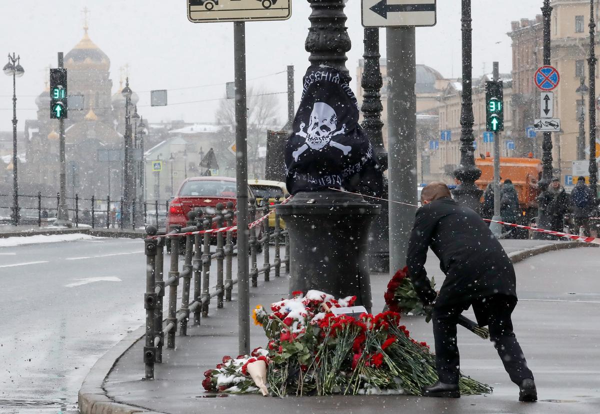 A man lays flowers in memory of assassinated Russian military blogger Vladlen Tatarsky in St. Petersburg on 3 April 2023. Photo: EPA-EFE / ANATOLY MALTSEV