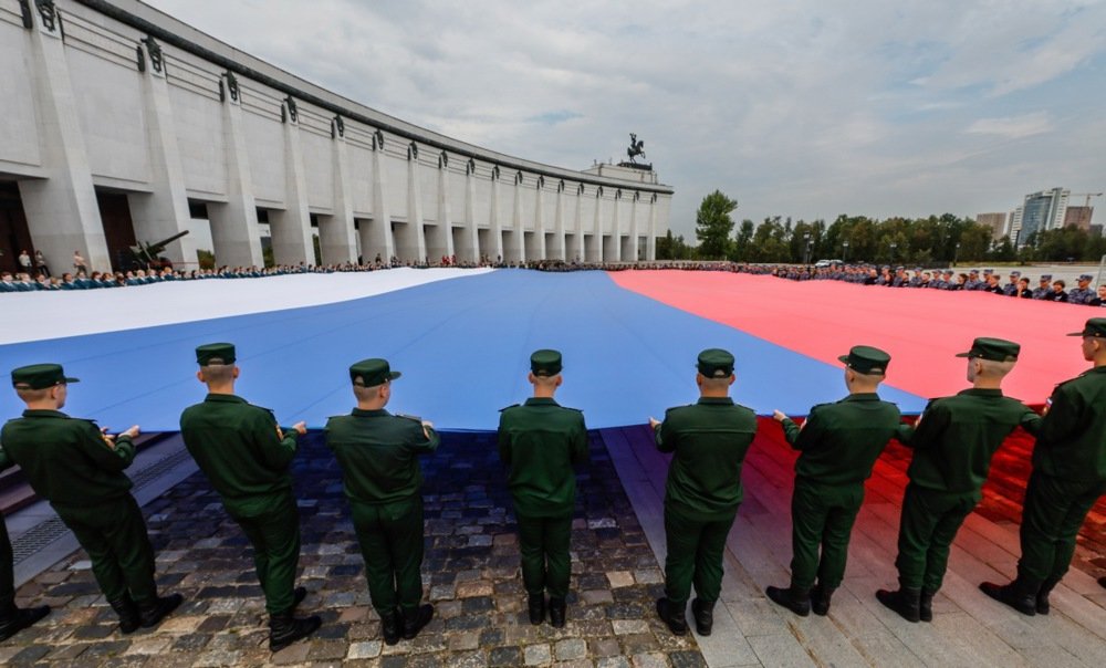 Russian soldiers display a giant national flag in Moscow, August 2024. EPA-EFE / YURI KOCHETKOV