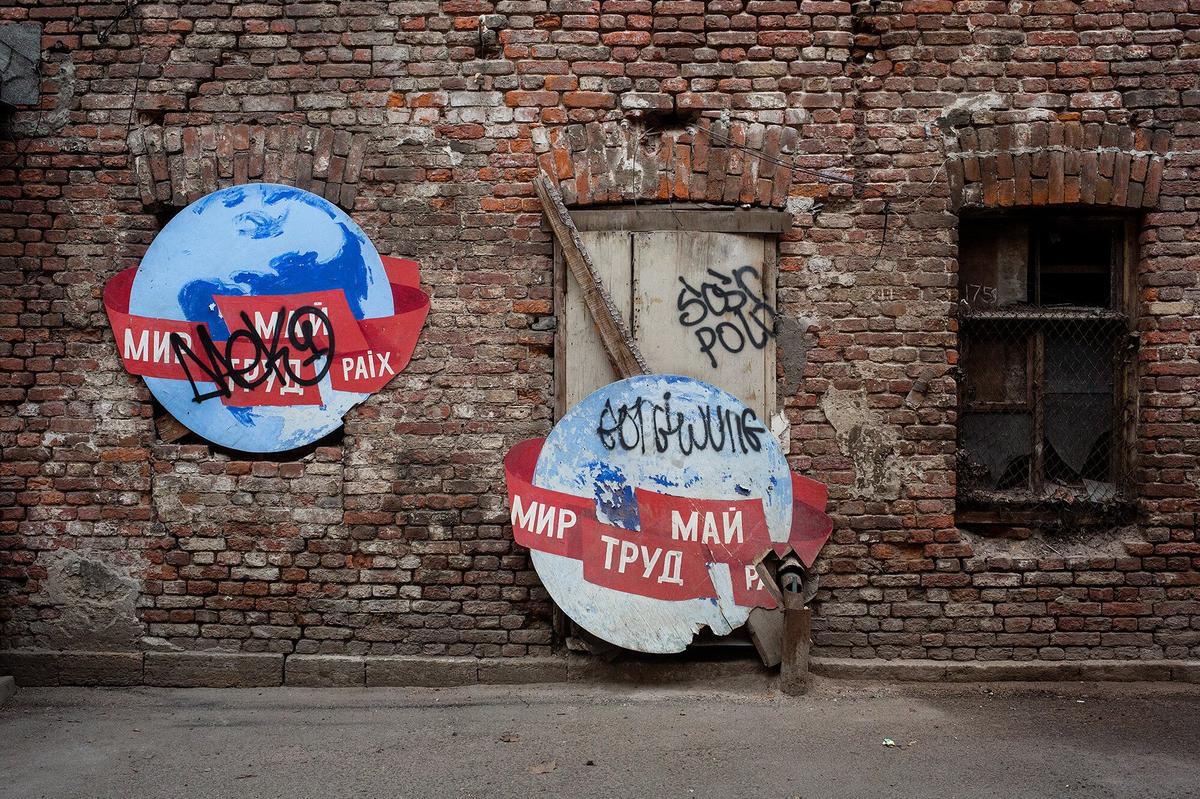 Старые плакаты с лозунгами «Мир, труд, май» выброшенные на помойку. Фото: Дмитрий Цыганов
