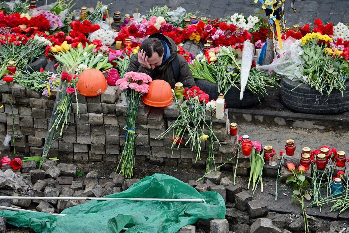 A protester laying flowers in memory of those killed on the Maidan, 23 February 2014. Photo: Jeff J Mitchell / Getty Images