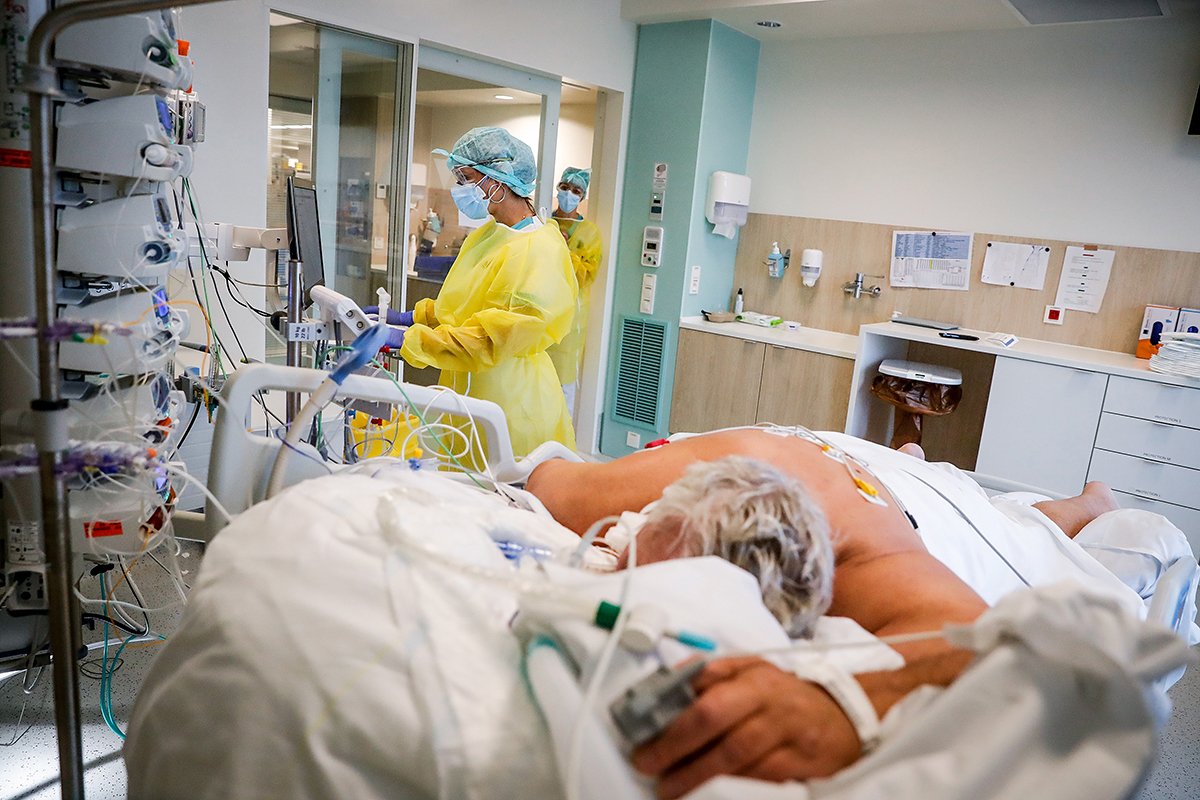 Медсестра ухаживает за пациентом с заболеванием COVID-19 в отделении интенсивной терапии в Эттербеке-Икселле больницы Iris Sud в Брюсселе, Бельгия, 19 ноября 2021 года. Фото: Stephanie Lecocq / EPA-EFE