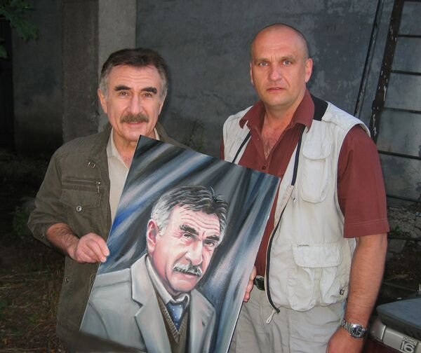 Yevgeny Chanov gifts a portrait to Leonid Kanevsky, a Russian TV host and film actor. Photo: social media