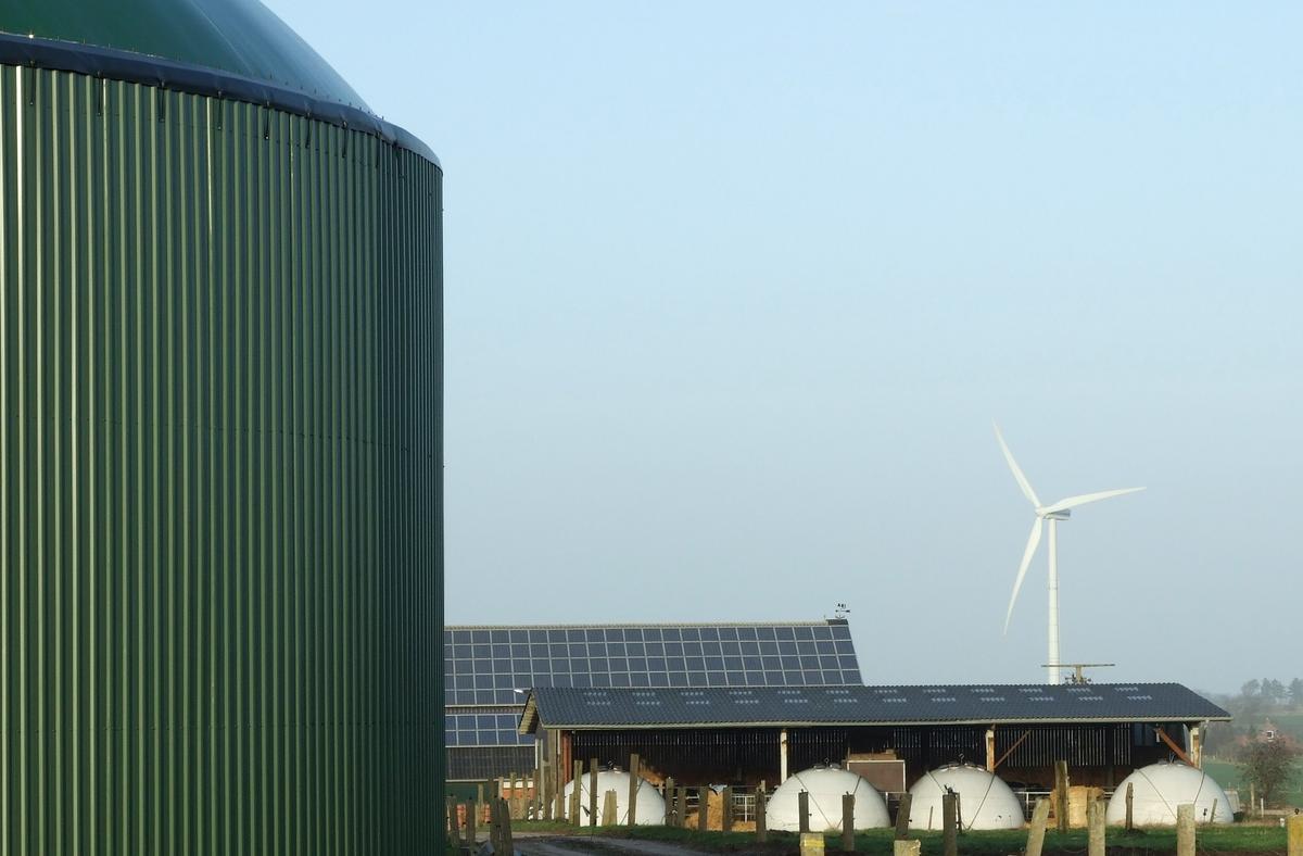 An installation for biogas production, photovoltaic panels, and a wind turbine, Schleswig-Holstein, Germany. Photo:  Wikimedia Commons , Florian Gerlach (Nawaro). CC BY-SA 3