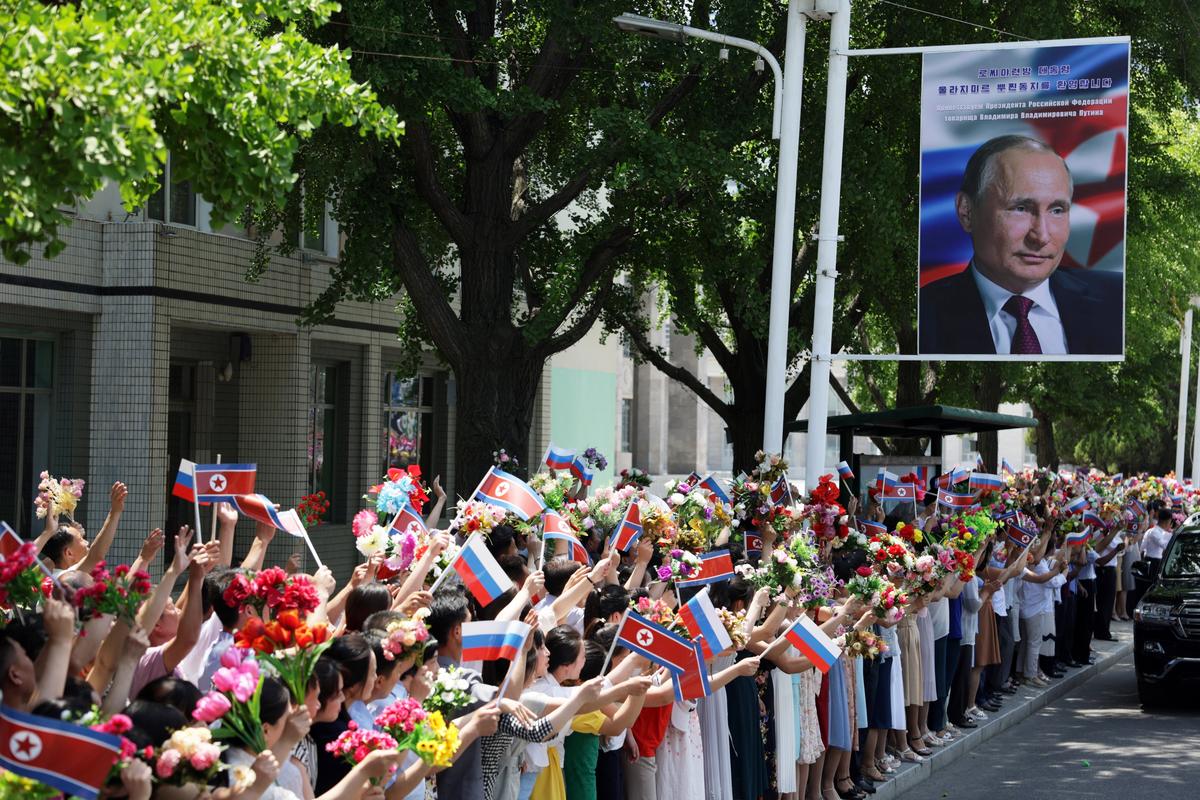 Crowds line the streets waving Russian and North Korean flags as Putin and Kim’s motorcade passes through Pyongyang. Photo: EPA-EFE / GAVRIIL GRIGOROV / SPUTNIK / KREMLIN POOL