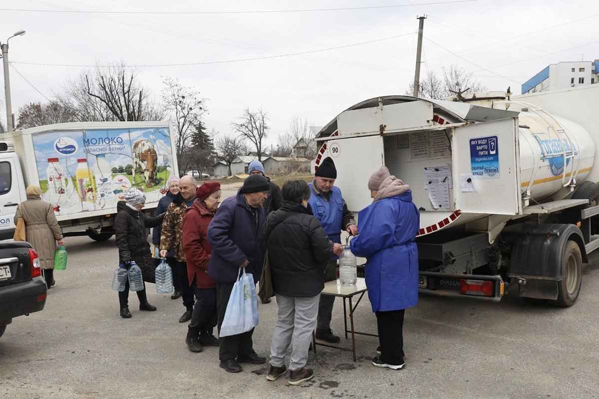 Люди набирают воду из водовоза после ракетного удара по объектам энергетики в городе Харьков, Украина, 22 марта 2024 года. Фото: Сергей Козлов / EPA-EFE