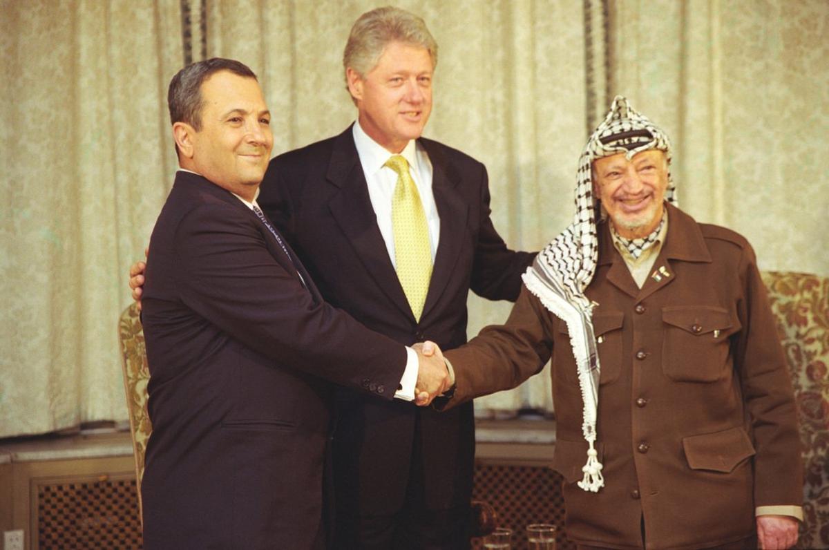 Премьер-министр Израиля Эхуд Барак и председатель Палестинской автономии Ясир Арафат пожимают друг другу руки во время трехсторонней встречи в резиденции посла США в Осло, Норвегия Фото: Sharon Farmer / U.S. National Archives (PD)