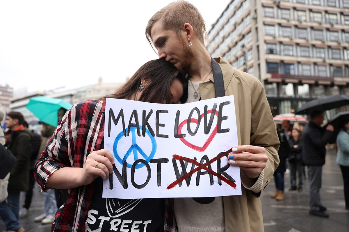 Пара держит плакат «Make love, not war» на митинге, посвященном второй годовщине российского вторжения в Украину, Белград, Сербия, 24 февраля 2024 года. Фото: Andrej Cukic / EPA-EFE