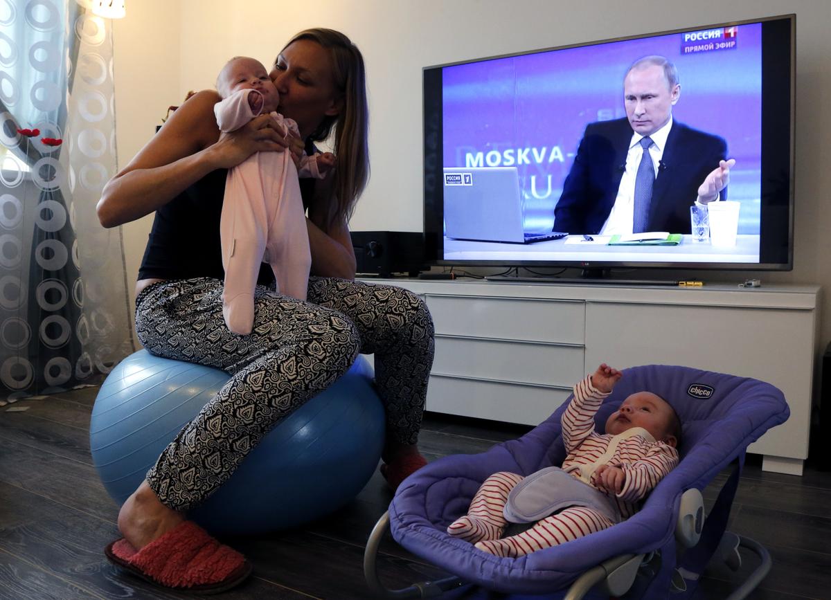 A young mother looks after her children at their home in St. Petersburg, Russia, 16 April 2015. Photo: EPA / Anatoly Maltsev
