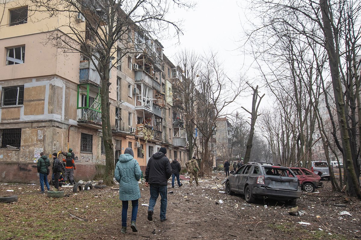 Местные жители осматривают повреждения в жилом доме рядом с местом ракетного обстрела торгового центра в Днепре, 29 декабря 2023 года. Фото: Arsen Dzodzaiev / EPA-EFE